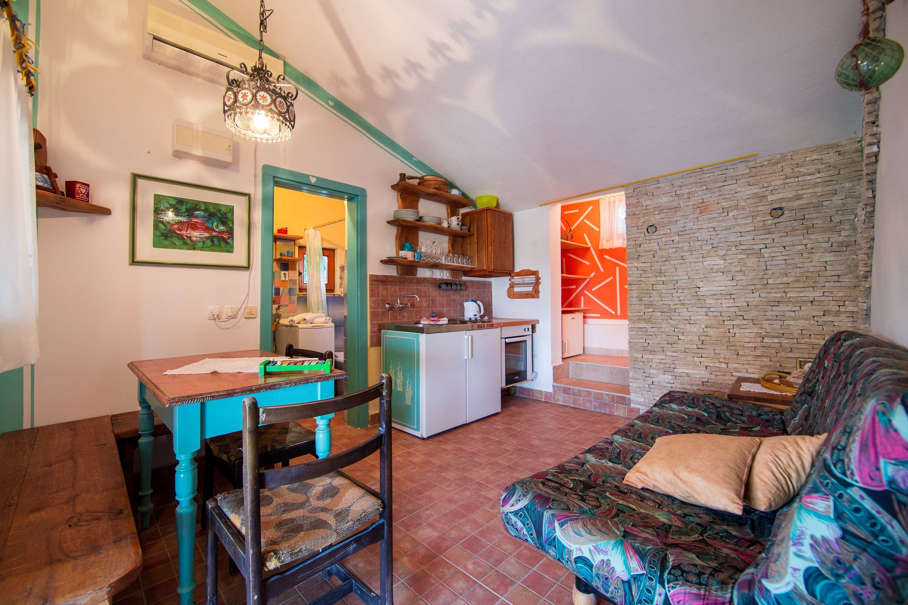A compact living space with a dining table, a sofa, and a kitchenette.
