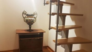 A corner with a wooden cabinet and a metal ladder. - Casa Bella del Borgo 2 (Bologna)