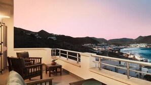 A balcony with a view of a coastal town at dusk. - Casa Hayman        . (Ventorros de San José)