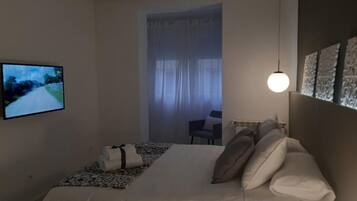 2 dormitorios y tabla de planchar con plancha