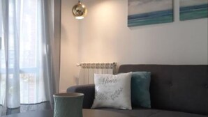 Una sala de estar moderna con una mesa redonda, un sofá y dos lámparas colgantes.