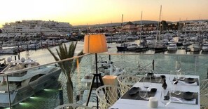 Enjoy waterfront dining with a view of the marina and boats docked nearby.