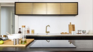 A modern kitchen with a large white sink, a black countertop, and a wooden cutting board. - Macchi Master Guest apartment (Milan)