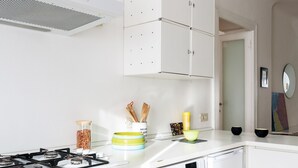 A modern kitchen with white cabinets, a gas stove, and a dishwasher. - Siri Master Guest apartment (Milan)
