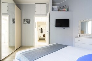 A bedroom with a bed, a television, a wardrobe, and a mirror. - Pascoli Master Guest apartment (Sesto San Giovanni)