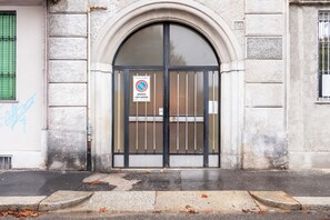 Enter through the grand arched doorway, flanked by stone walls, into this historic building.