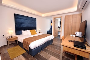 Ein modernes Hotelzimmer mit einem großen Bett, einem Schreibtisch, einem Stuhl und einem Kleiderschrank.
