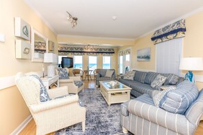 A living room with a sofa set, a coffee table, and a television.