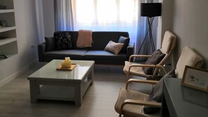 Una sala de estar con un sofá, una mesa de centro y una lámpara de pie.
