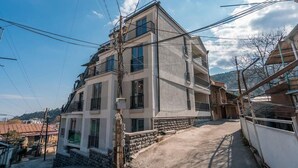 Un immeuble à plusieurs étages doté de balcons et d’une allée pavée.