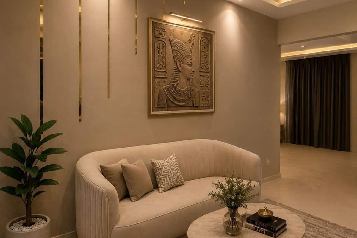 A modern living room with a beige sofa, a round coffee table, and a potted plant.