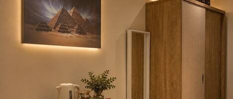 A modern kitchen with a refrigerator, a coffee maker, and a tea set on the counter.
