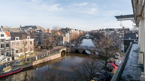 Un canal surmonté d’un pont, bordé de bâtiments et de voitures garées.