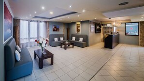 A modern hotel lobby with a reception desk, sofas, a coffee table, and a large window with curtains. - Cloud 9 Hotel Shisha & Cocktail Bar - Adults Only (Hersonissos)