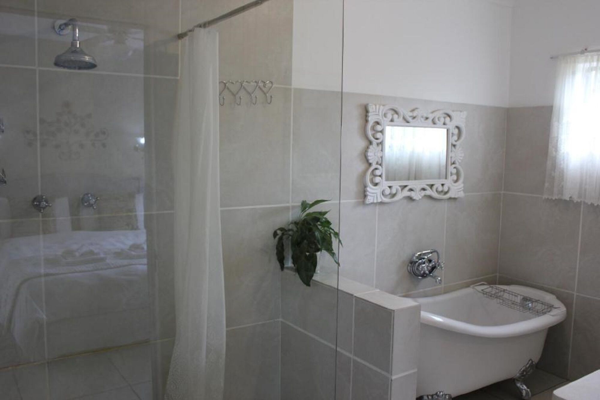 A bathroom with a shower, a bathtub, a sink, and a mirror.