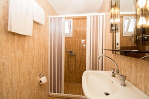 A bathroom with a shower, sink, and mirror. - Divina Apartments  by Estia (Hersonissos)