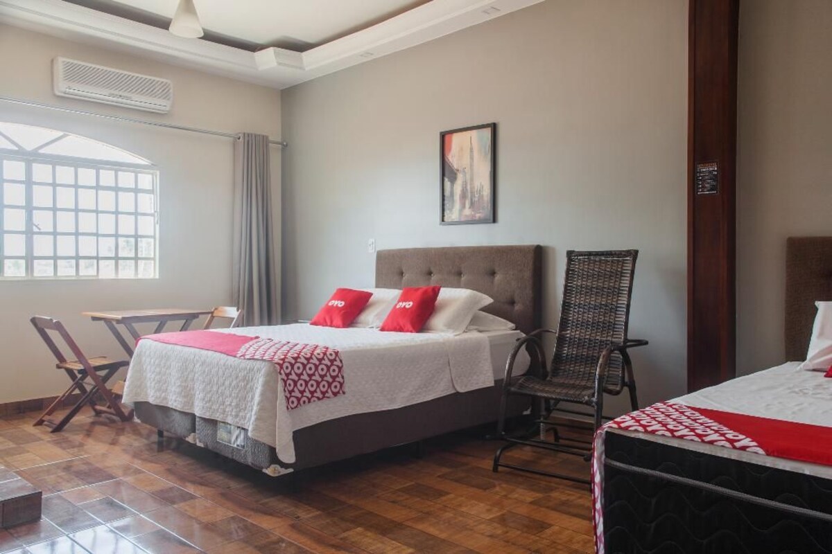 Une chambre d’hôtel avec un lit, une chaise, une table et une fenêtre.