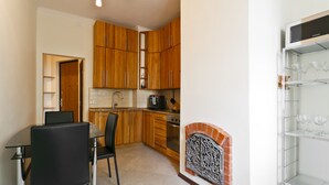 A compact kitchen with wooden cabinets, a built-in oven, and a glass display shelf. - MinskLux Apartment 2 bedroom Nezavisimosti 12 (Minsk)