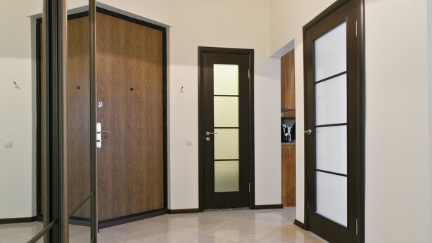 A hallway with a wooden door, a glass door, and a ceiling light. - MinskLux Apartment 2 bedroom Nezavisimosti 12 (Minsk)