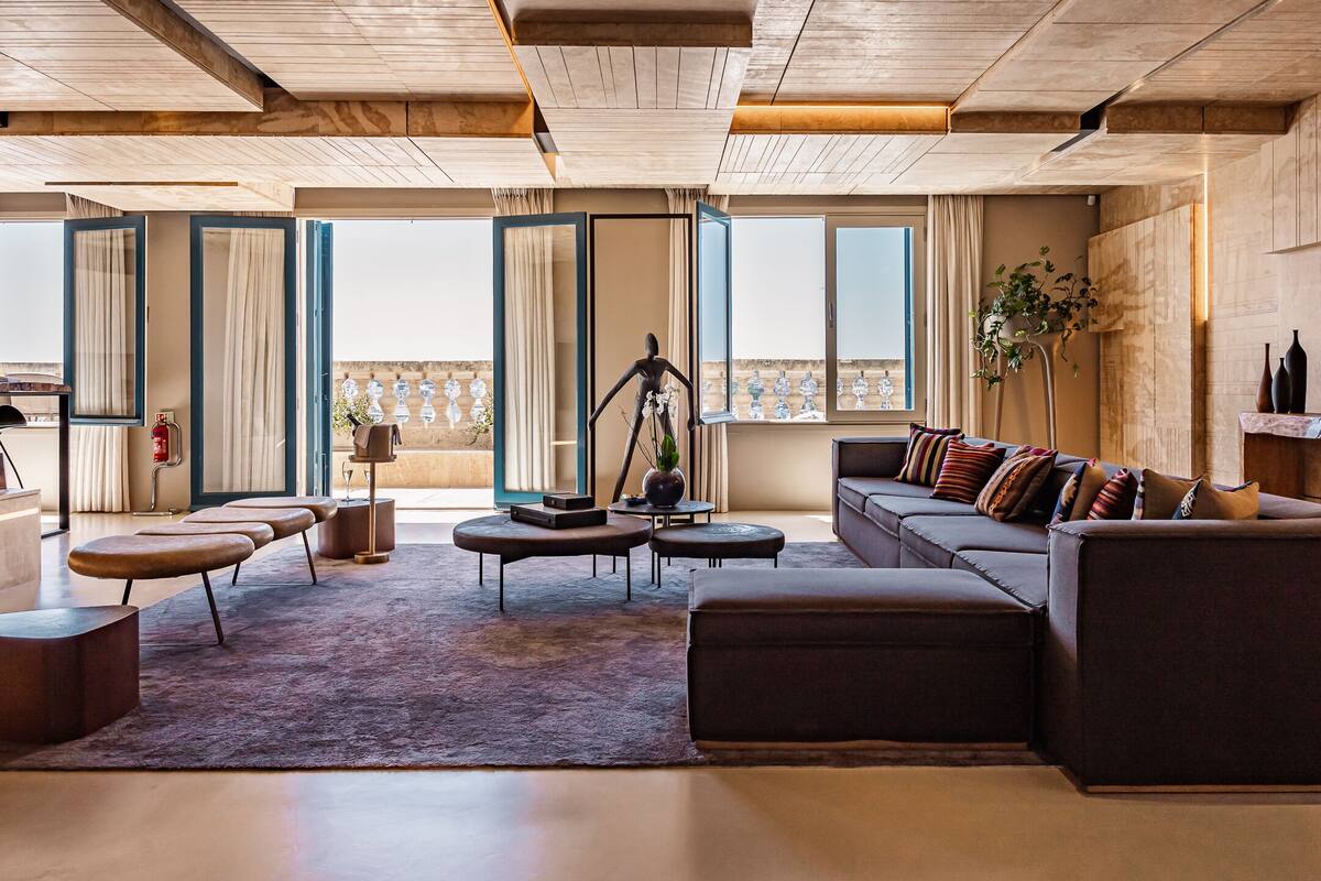 Amplia sala de estar con un sofá moderno, una mesa de centro y un ventanal con vistas a la ciudad.