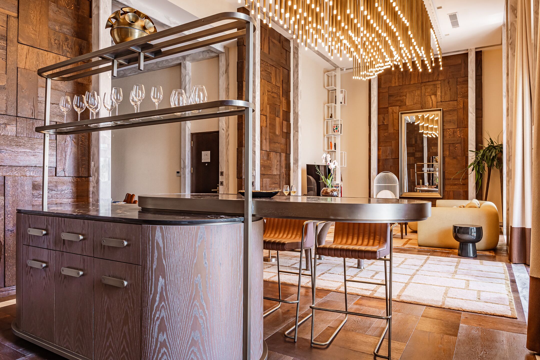 Eine moderne Bar mit einer Holztresore, Metallhockern und einem Weinkühlschrank.