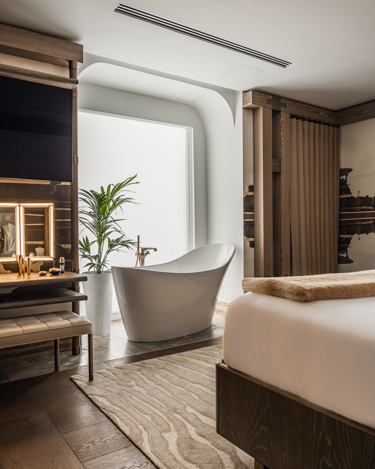 Un bagno moderno con una vasca freestanding, un mobile lavabo con specchio e una pianta in vaso.