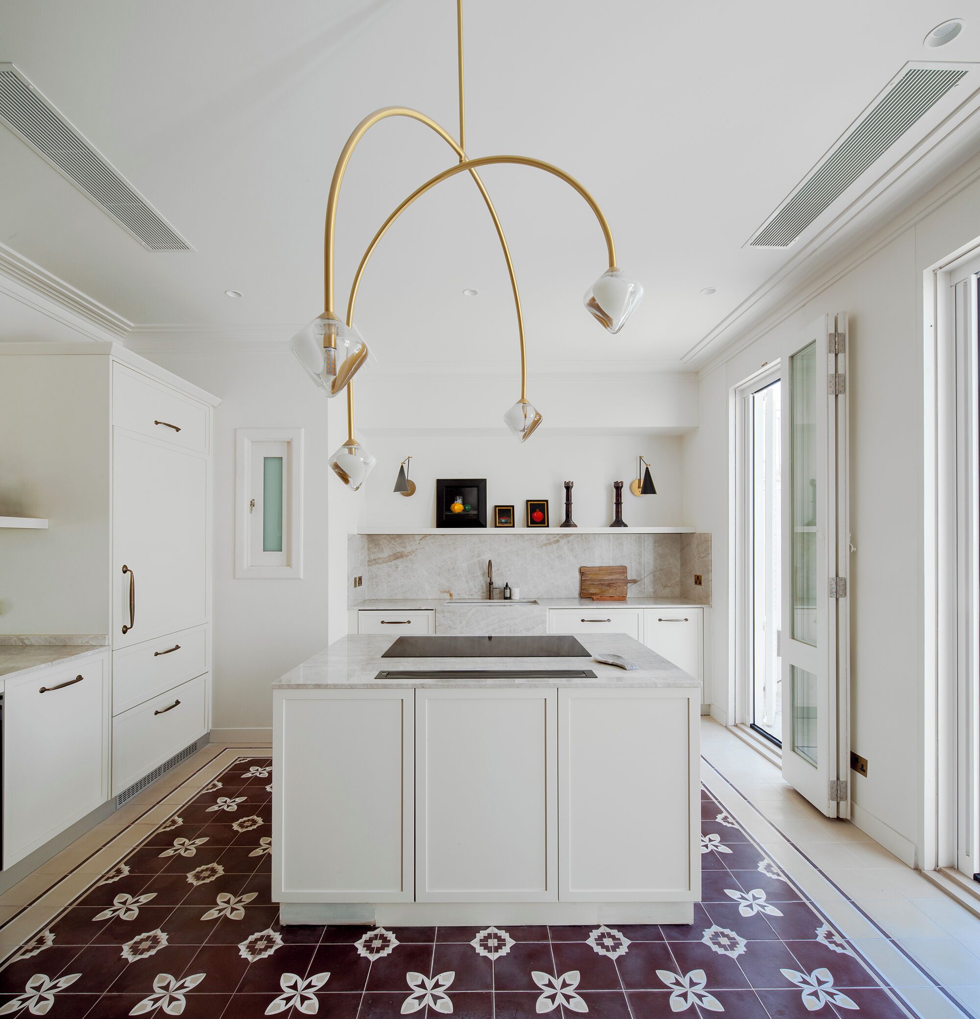 A modern kitchen with white cabinetry, a marble countertop, and a central island.
