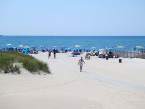 Ein Strand mit Menschen, Sonnenschirmen und Liegestühlen.