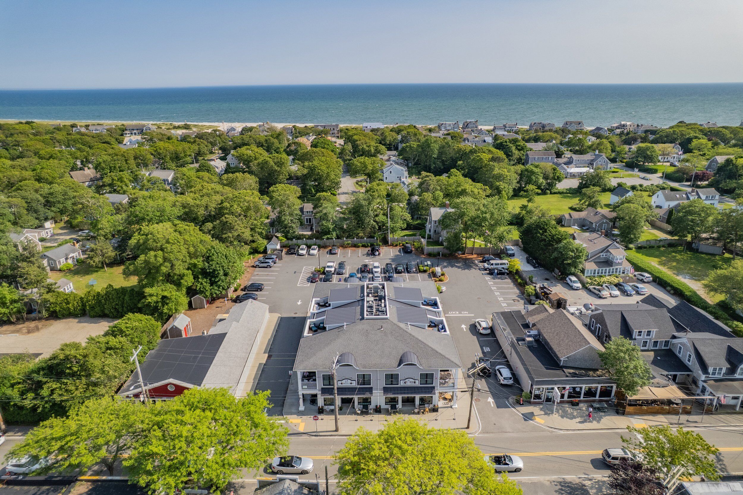 Un quartier résidentiel situé sur la côte, avec des maisons, un parking et une vue sur l’océan.