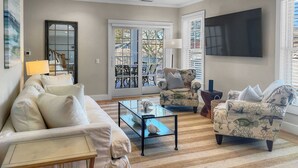 A living room with a sofa, armchairs, a coffee table, and a TV. - TJs Tide: Prime Location Condo w/ Outdoor Deck (Harwich Port)