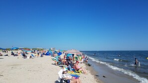 A crowded beach with people sunbathing and swimming. - TJs Tide: Prime Location Condo w/ Outdoor Deck (Harwich Port)