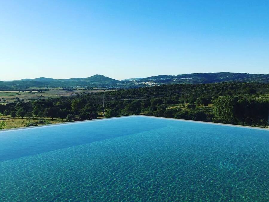 Una piscina al aire libre, sillones reclinables de piscina