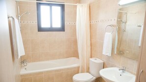 A bathroom with a bathtub, toilet, and sink. - Private Roof Top Terrace Overlooking Pool in Pyla (Pyla)