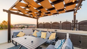 An outdoor patio with a pergola, seating, and a view of the city. - Private Roof Top Terrace Overlooking Pool in Pyla (Pyla)