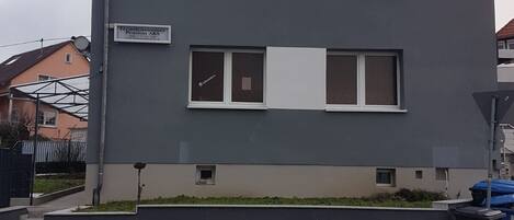 A two-story building with a flat roof, large windows, and a sign indicating it is a pension.