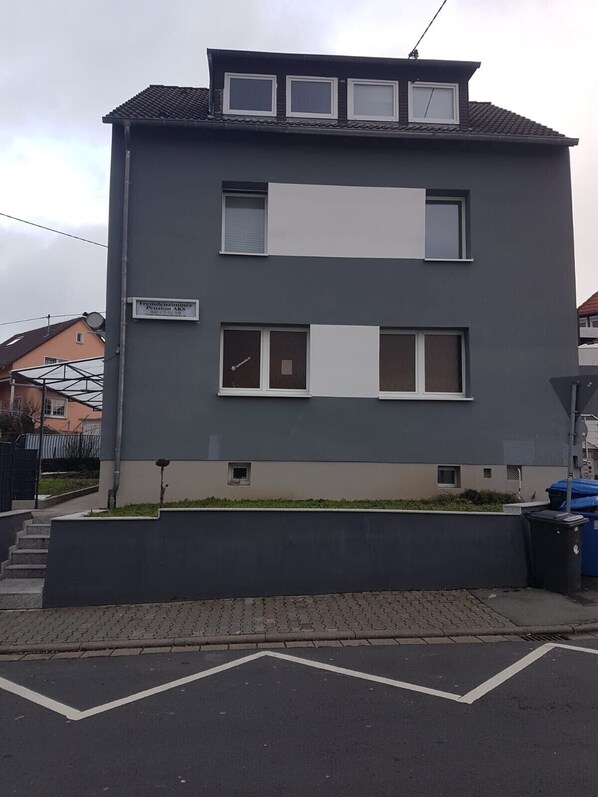A two-story building with a flat roof, large windows, and a sign indicating it is a pension. - Monteurzimmer AKS (Hofheim am Taunus)