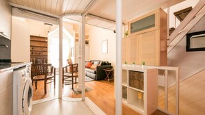 Un espacio habitable compacto con cocina, comedor y una escalera.