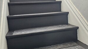 Uma escadaria com degraus escuros e rodapé branco.
