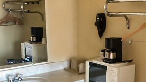 A compact hotel room with a sink, a microwave, and a refrigerator. - OYO Hotel Guymon OK US-54 (Guymon)