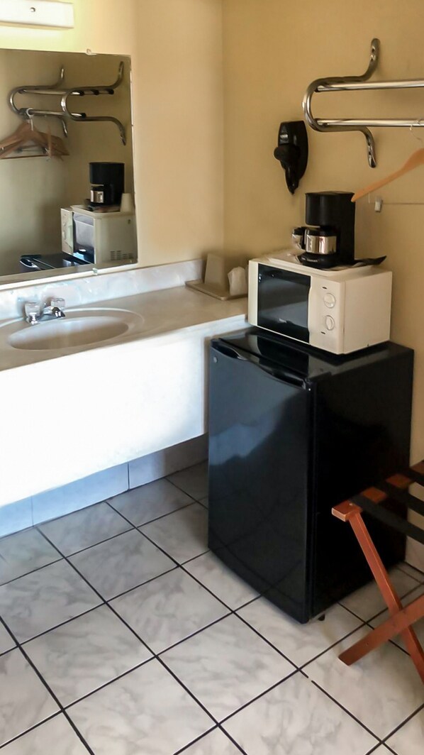 A compact hotel room with a sink, a microwave, and a refrigerator. - OYO Hotel Guymon OK US-54 (Guymon)
