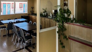 A dining area with tables and chairs, a kitchen area with cabinets and appliances, and a view of the outside through a window with blinds. - OYO Hotel Guymon OK US-54 (Guymon)