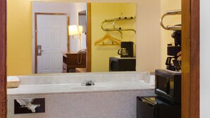 A bathroom with a sink, mirror, and a coffee maker. - OYO Hotel Guymon OK US-54 (Guymon)