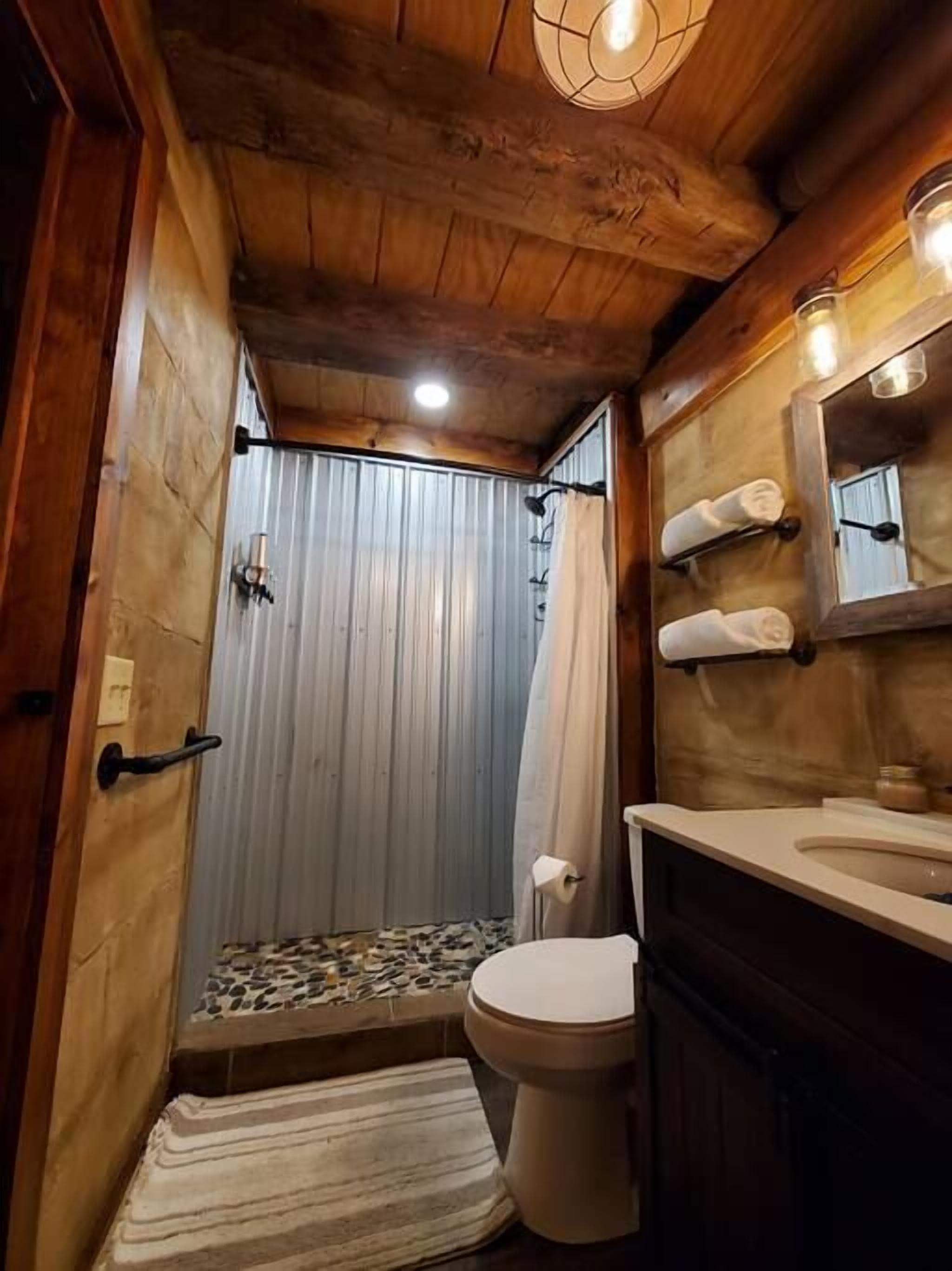 A compact bathroom with a shower, toilet, and sink.