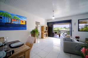 Un vaste espace de vie comprenant une table à manger, un canapé et un tableau accroché au mur.