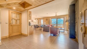 A spacious living area with a wooden ceiling, a dining area with a table and chairs, and a view of mountains through large windows. - 100m from resort center, 12nd floor, balcony, parking, tv, ski locker, 90m², Champagny-en-Vanoise (Champagny-en-Vanoise)
