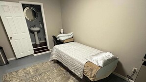 A bedroom with a bed, a rug, a sink, and a door. - Delightful Guest Room Close to Hendersonville’s Downtown (Hendersonville)