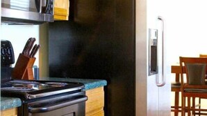 Una cocina con armarios de madera, un refrigerador de acero inoxidable, un microondas y un horno.