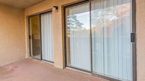 A building with a beige exterior, a concrete floor, and a large sliding glass door with a metal handle. - Spacious 2BR Apartment in Prime Location (Chattanooga)