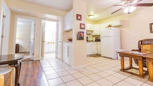A spacious kitchen with white cabinets, a refrigerator, and a ceiling fan. - Spacious 2BR Apartment in Prime Location (Chattanooga)