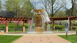 A water fountain with a stone base, surrounded by a paved walkway and benches. - Cozy 1 BR efficiency apt close to TTU and downtown (Cookeville)